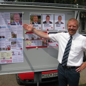Dieter Gronert präsentiert Flyer und Plakat im Schaukasten der Rahdener Sozialdemokraten.
